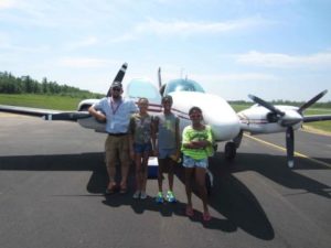 angel-flights-central---girls-posing-outside-plane-with-pilot-lo-res